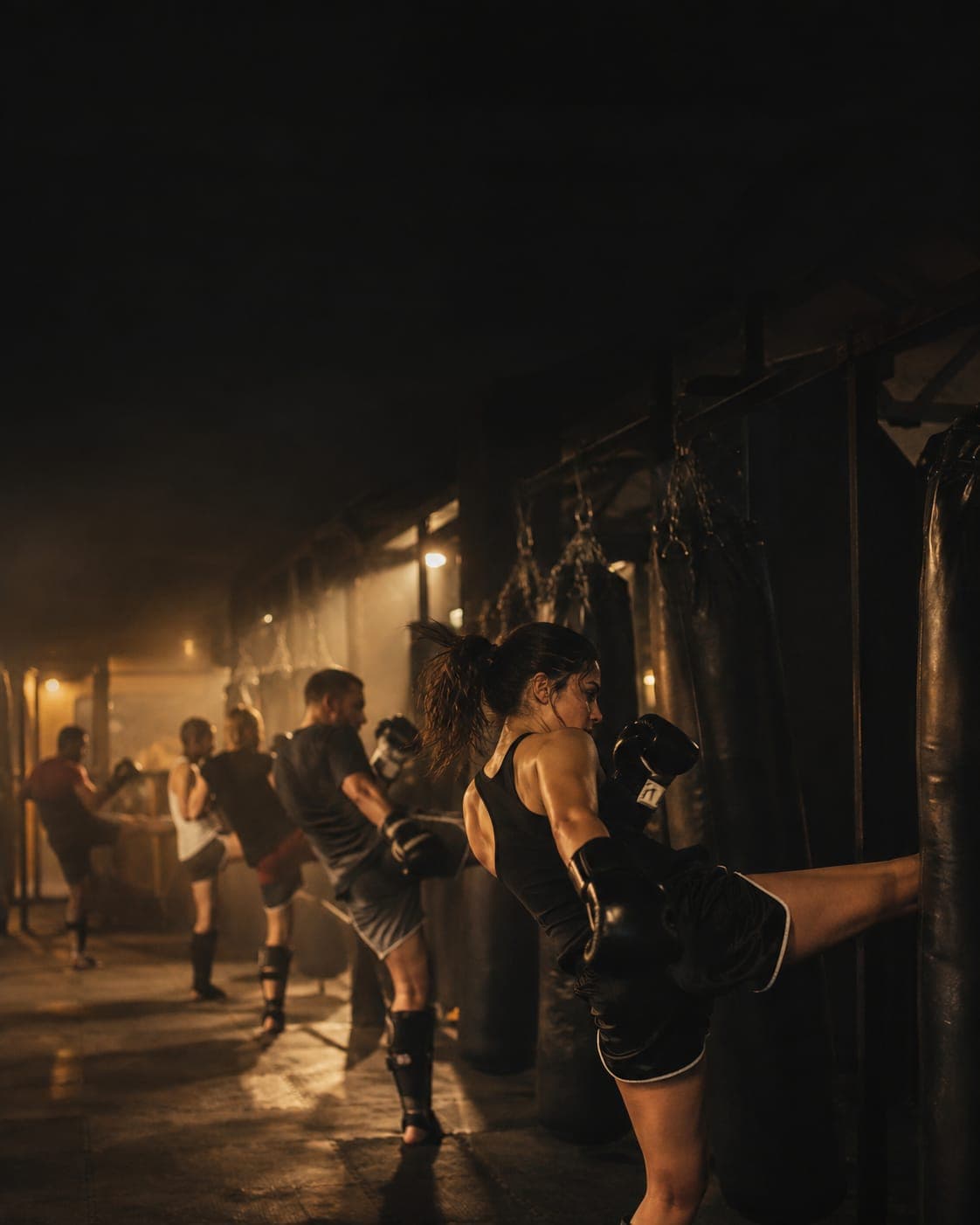 Clase de muay thai: alumnos pateando los sacos